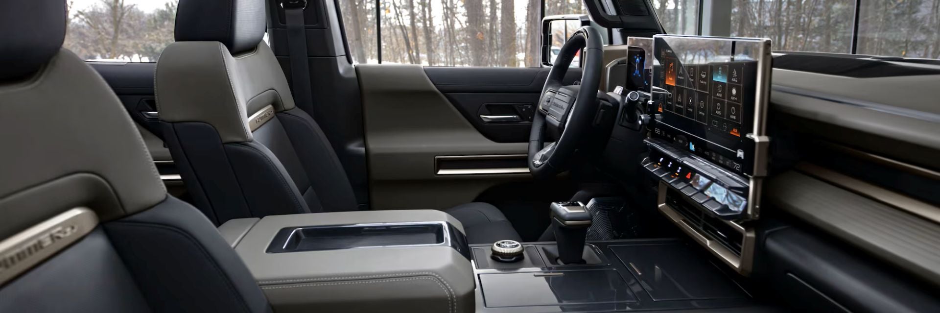 Interior of a GMC Hummer EV showing premium seats, digital display, and modern dashboard controls.